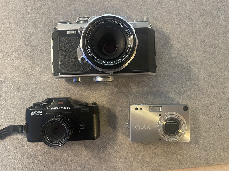 Eine Edixa-Kamera, eine Pentax und die Pentax Auto 110 Super (entgegen dem Uhrzeigersinn)