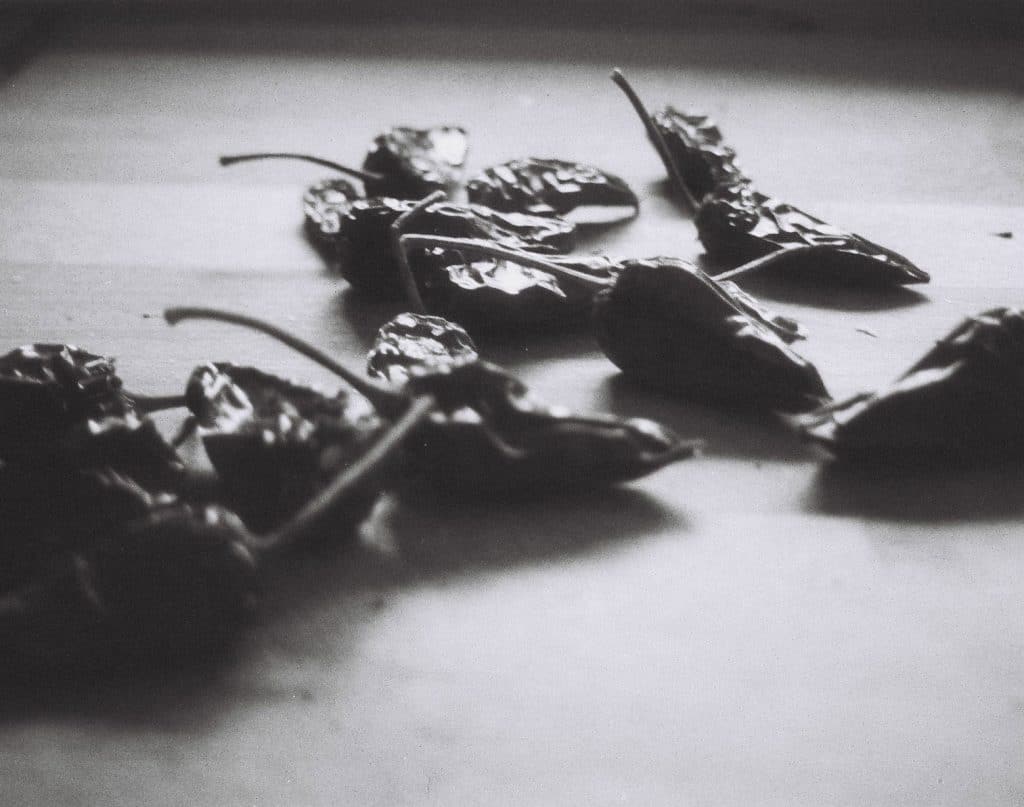 Chilischoten auf einem Tisch, in Schwarz.Weiß