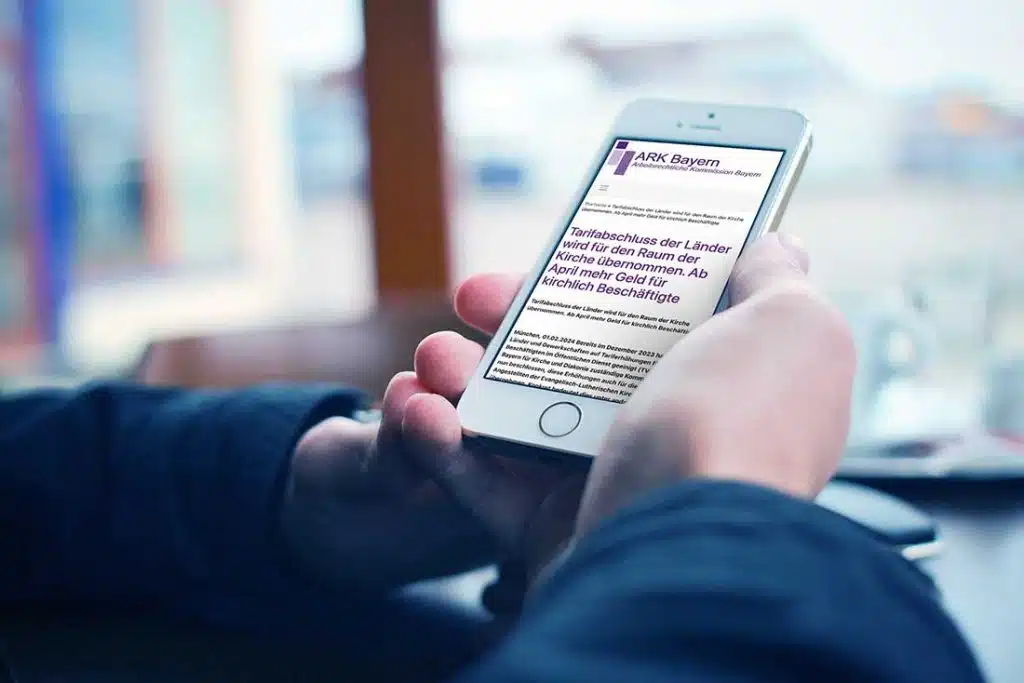 Ein Handy in der Hand eines Menschen, darauf ein Text