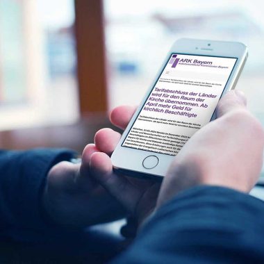 Ein Handy in der Hand eines Menschen, darauf ein Text